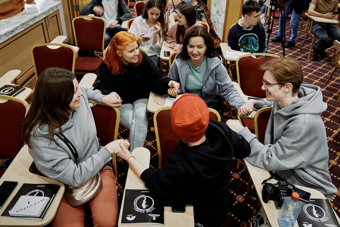 Team holding hands in a circle during a meeting.